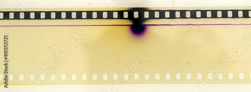 real macro photo of overexposed 35mm cine film strip with dust and nice details on white background.