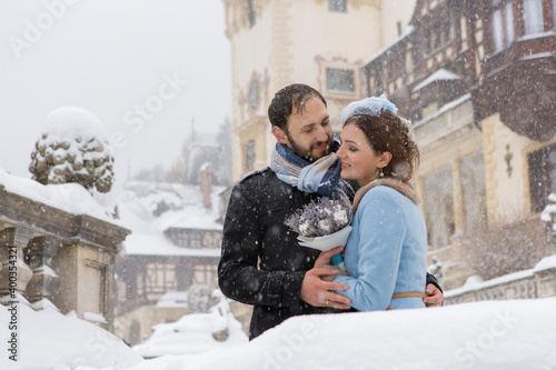 Billede på lærred Happy Young Couple in Winter Park. Family outdoors at the castle.