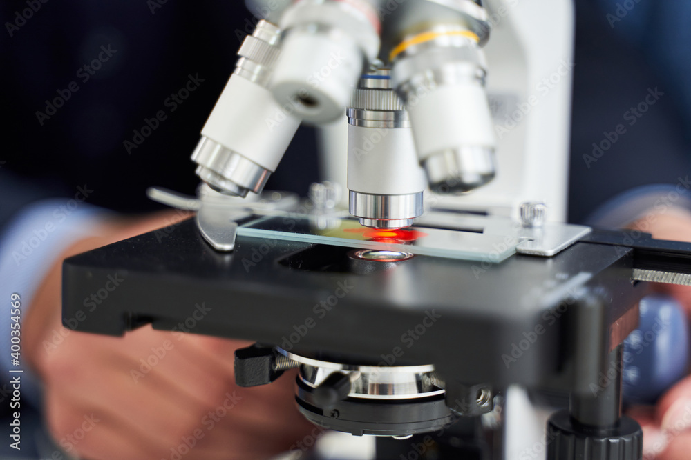 Cropped view of teacher adjustings a microscope