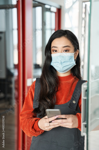 Successful female student with dark hair wearing protective mask