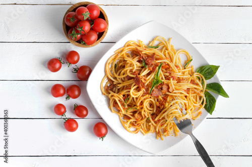 Delicious  spaghetti amatriciana sauceon a light concrete and tomato sauce on white plate photo