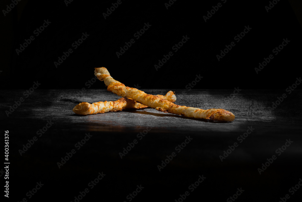 Cheese bread sticks, baked on a dark gray background. Cheese bread sticks, baked on a dark gray background.