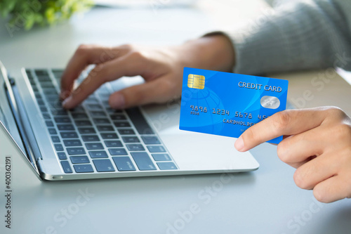 Business woman hand holding credit card and use laptop