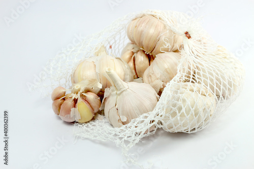the garlic in net bag for sale on white background
