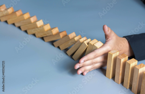 businessman hand Stopping Falling wooden risk successful intervention concept for business