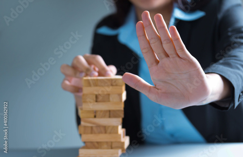 a male hand stopping the domino effect.executive and risk control concept