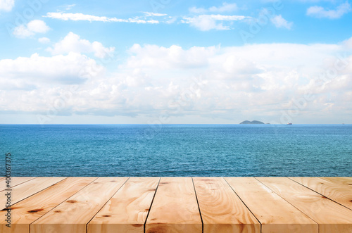 image of Wooden table in front of blue sea and bright landscape