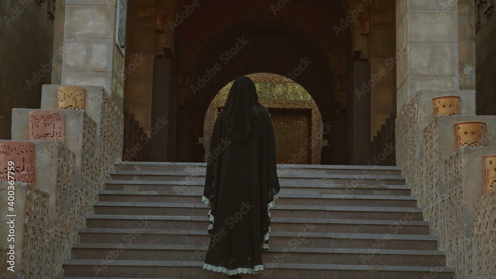 Back of a veiled woman in an ancient building