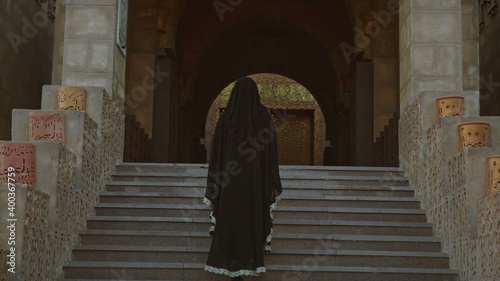 Back of a veiled woman in an ancient building