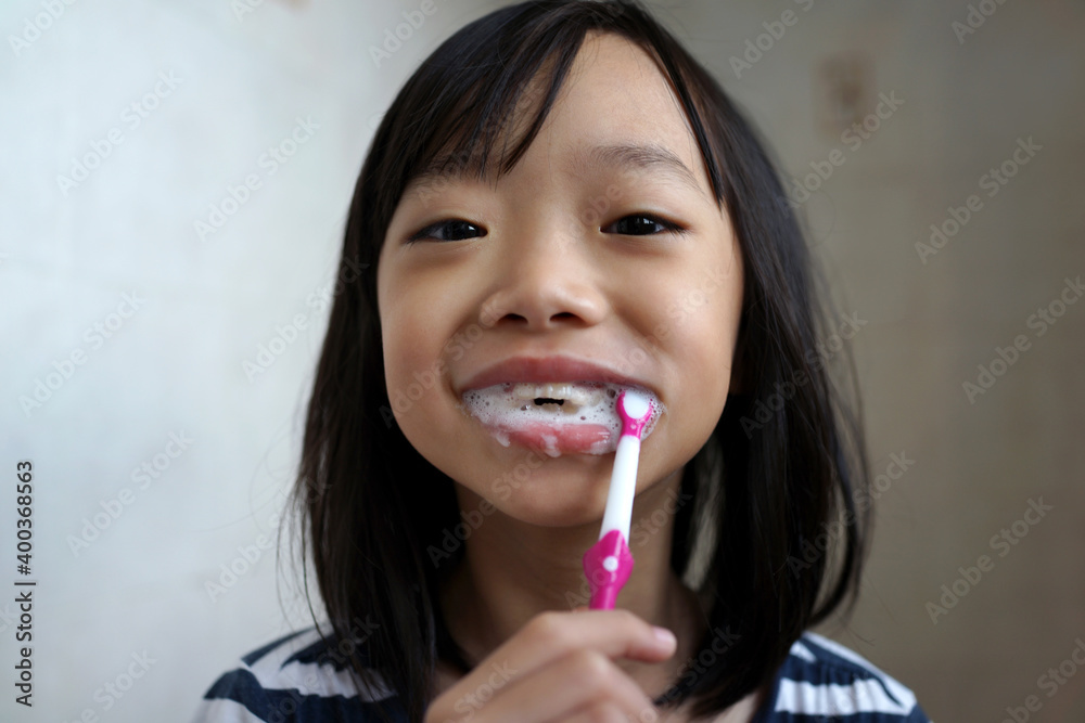 Portrait of little Asian girl brushing teeth at the bathroom Portrait of little Asian girl brushing teeth at the bathroom