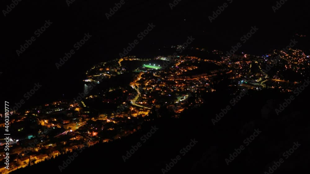 Shot of aerial landscape of colorful city at night. Light around. Old city near sea. Building town residential night street travel city tourist architecture. Slow motion Shot of aerial landscape of colorful city at night. Light around. Old city near sea. Building town residential night street travel city tourist architecture. Slow motion