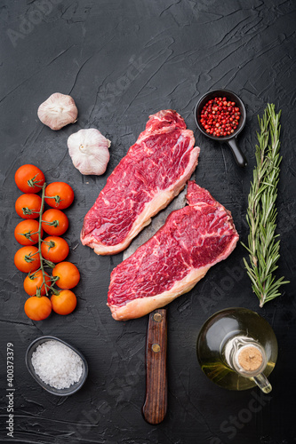 Strip loin steak, raw marbled meat, on black background, top view