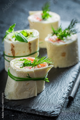 Closeup of tortilla with red salmon and green vegetables