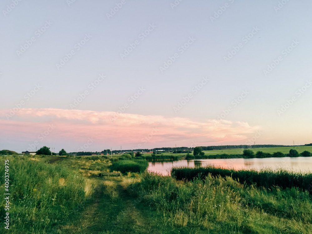Summer landscape on the shore of a pond in the setting sun Summer landscape on the shore of a pond in the setting sun