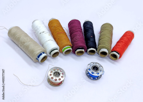 Old vintage hand sewing machine Colored thread coils or bobbin on white background, sewing machine accessories. selective focus. image