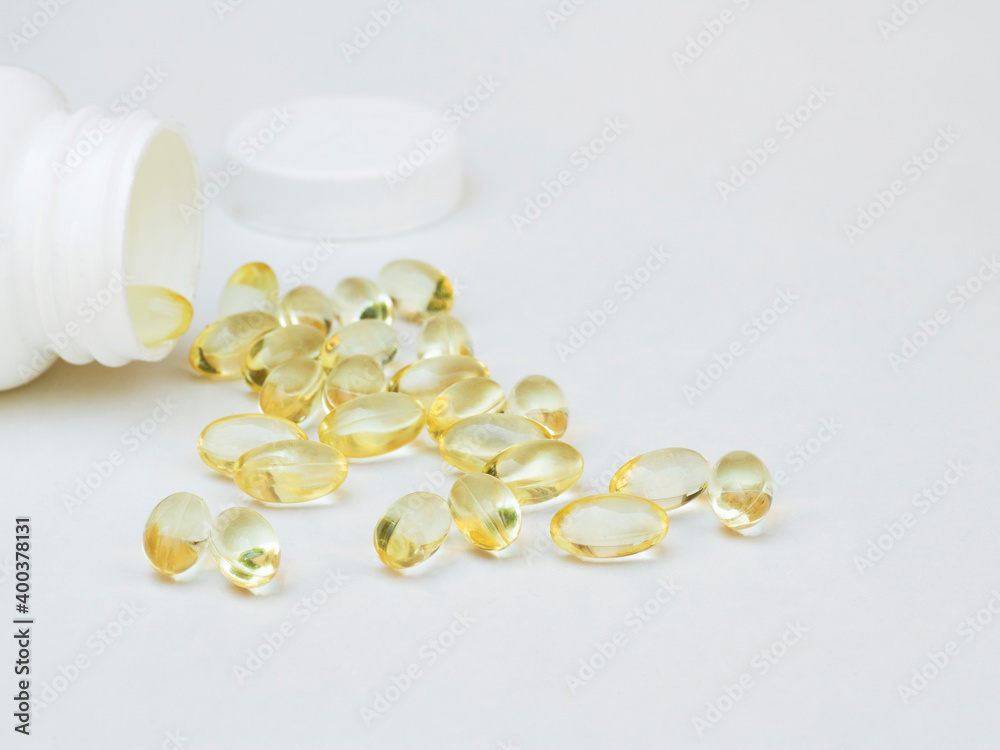medicine vitamins fish oil softgel spilling out from plastic pill bottle on white. Medical concept. medicine vitamins fish oil softgel spilling out from plastic pill bottle on white. Medical concept.