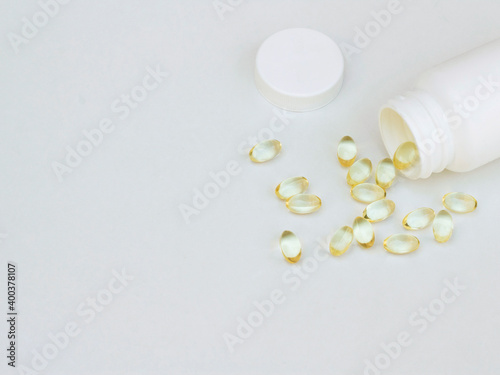 medicine vitamins fish oil softgel spilling out from plastic pill bottle on white. Medical concept. 