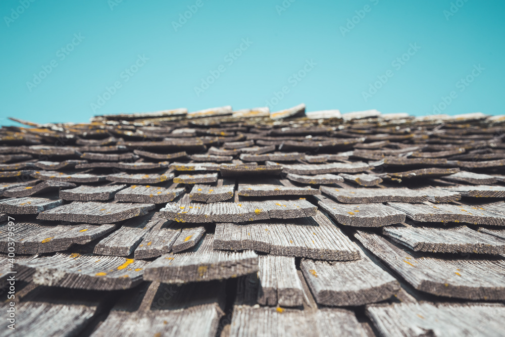 Weathered old shingles on bad state house, blue sky Weathered old shingles on bad state house, blue sky