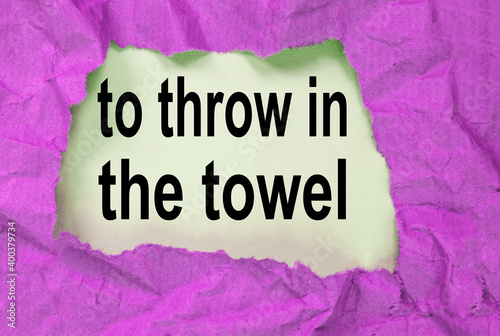 throw in the towel-phrase message through a hole in the crumpled wrapping paper, conceptual image, top view