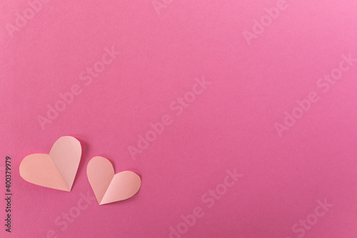 Paper pastel pink hearts on a pink background. the concept of romance, love and tenderness. Bright greeting card for Valentine's Day. Design of the anniversary of mother's Day. The view from the top.