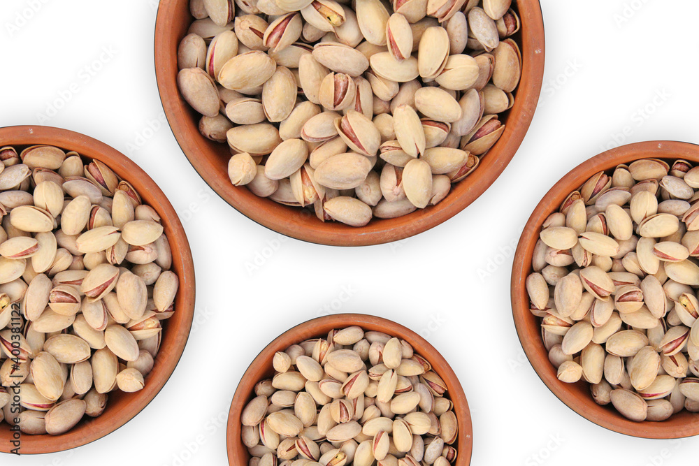 Top view of pistachios filled in four clay bowls on a white surface. Food photography of pistachios with top view. Pistachios in a clay bowl for facebook post. Top view of pistachios filled in four clay bowls on a white surface. Food photography of pistachios with top view. Pistachios in a clay bowl for facebook post.