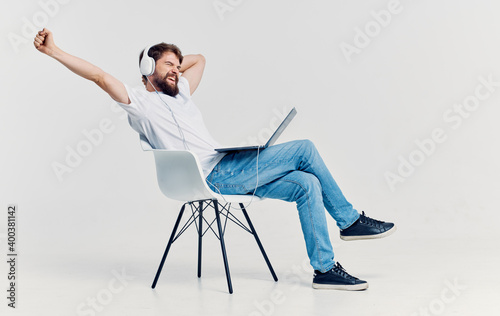 man in headphones in front of a laptop on a chair leisure lifestyle technology