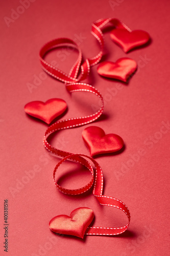 Valentines day hearts and ribbon on red background. Top view with copy space. Valentine's day concept.