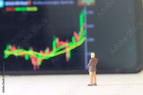 Simple Conceptual Photo, Illustration for Investor Mini Figure Toy Standing and Wacthing businessman Running Stock Exchange photo