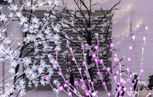 Trees with white and purple LED garlands. LED tree. photo