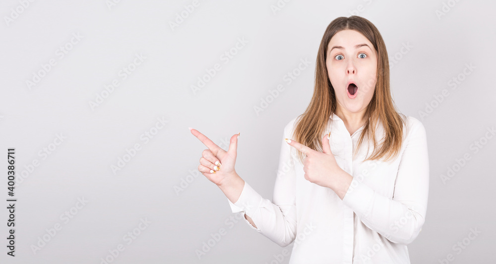 Photo of surprised woman points up, has shocked facial expression, wears white t shirt against white background. Wow concept. Photo of surprised woman points up, has shocked facial expression, wears white t shirt against white background. Wow concept.