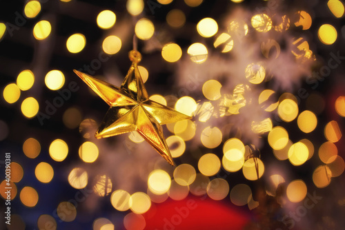 Golden star on abstract blurred shiny lights background. Merry christmas decoration concept and happiness party idea