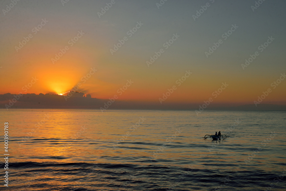 Silhoette of an outrigger boat during sunrise.