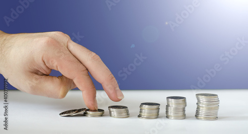 fingers walk over coin towers. money accumulation concept.