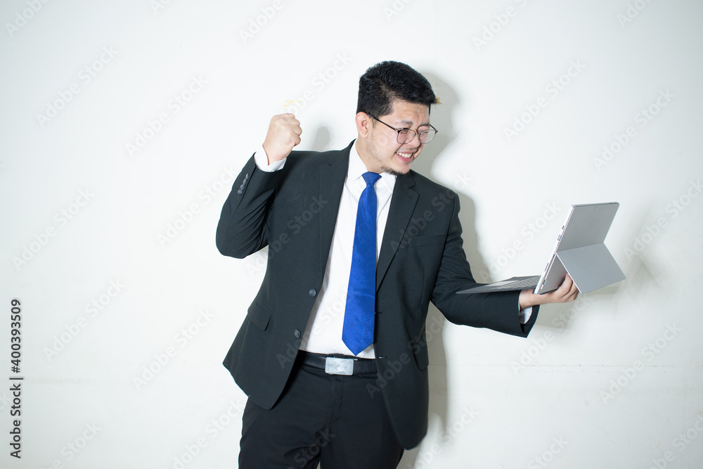 Happy young business man working on a laptop, isolated on white background Happy young business man working on a laptop, isolated on white background