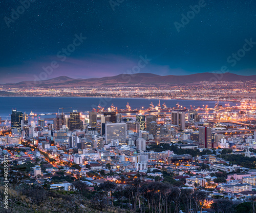 Cape Town city and harbour illuminated at night with blue sky and stars