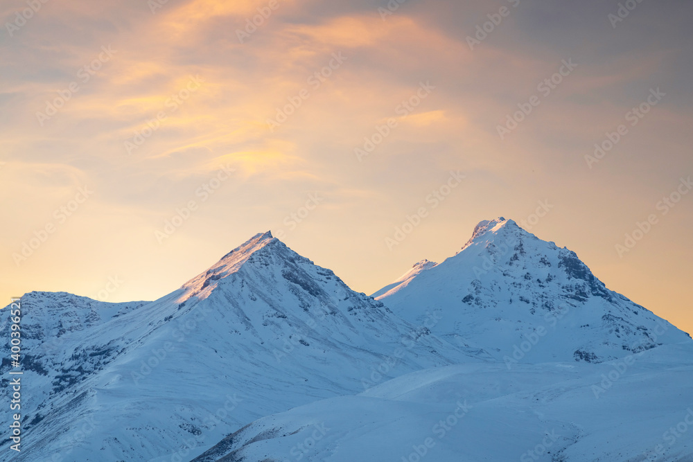 Beautiful winter landscape. The mountain peaks snow-covered on the sunset.