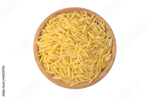In Greece called kritharaki. In Italy called Orzo. Rice shaped pasta in wooden bowl isolated on white background. Type of pasta. Food ingredient.