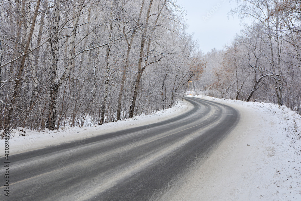 Snow-covered road in a snow-covered pine forest Snow-covered road in a snow-covered pine forest