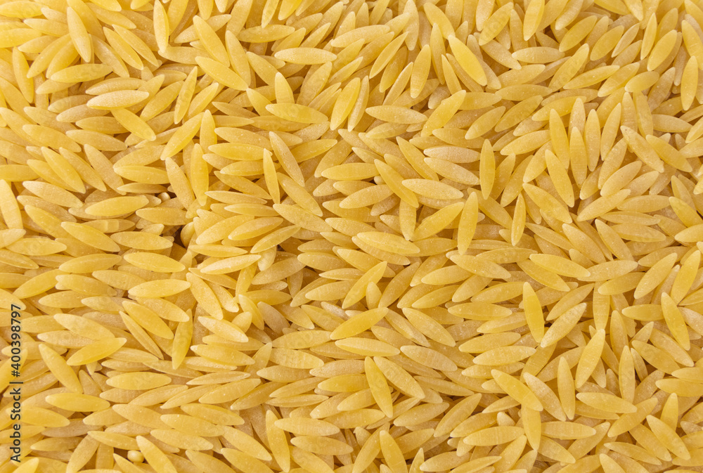 In Greece called kritharaki. In Italy called Orzo. Rice shaped pasta background. Type of pasta. Food ingredient. In Greece called kritharaki. In Italy called Orzo. Rice shaped pasta background. Type of pasta. Food ingredient.
