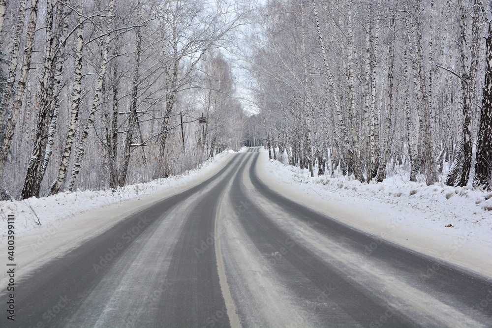 Snow-covered road in a snow-covered pine forest Snow-covered road in a snow-covered pine forest