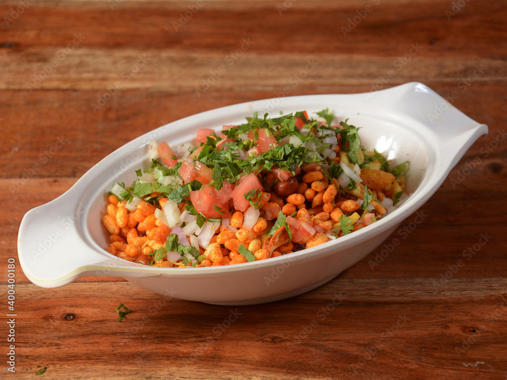 Bhel puri, a famous midday snack in india, served over a rustic wooden background, selective focus Bhel puri, a famous midday snack in india, served over a rustic wooden background, selective focus