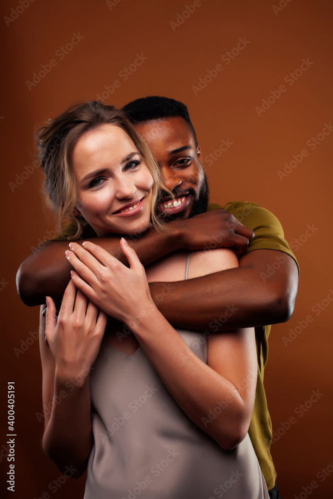 Fototapeta premium oung pretty couple diverse races together posing sensitive on brown background, lifestyle people concept