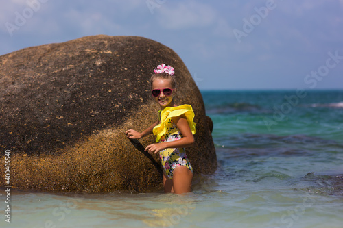 Child having fun at the beach, Cute girl playful in the sunny day, tropical beach.Playing with waves sea