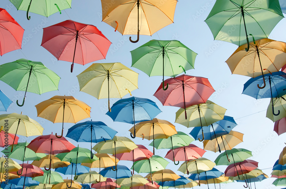 Plusieurs parapluies colorés suspendus sur ciel bleu
