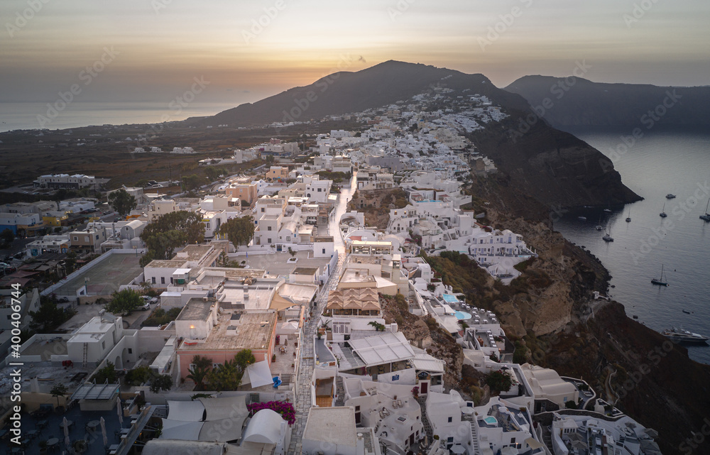 Oia town on Thira. Santorini island with colorful volcanic cliffs and deep blue sea aerial view