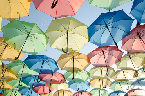 Plusieurs parapluies de toutes les couleurs suspendus en extérieur