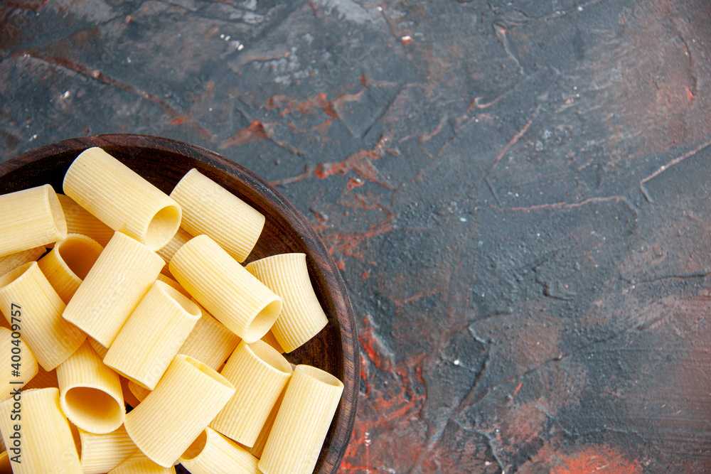Fototapeta premium Half shot of uncooked pastas inside the pot on black background