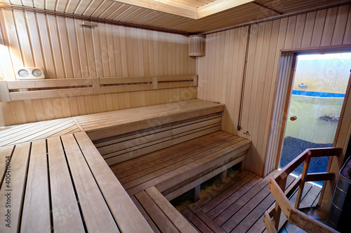 Russian sauna wooden bathhouse with stove and glass door to font. Bath and sauna are good means of preventing disorders of cardiovascular and respiratory systems.
