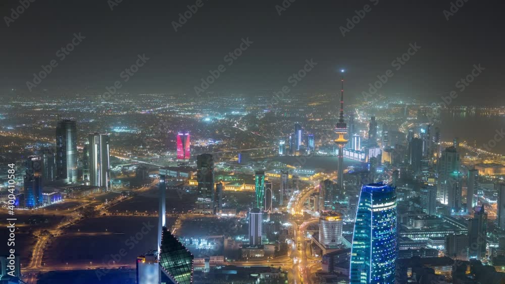 Skyline with Skyscrapers night timelapse in Kuwait City downtown illuminated at dusk. Aerial view from rooftop. Kuwait City, Middle East. Skyline with Skyscrapers night timelapse in Kuwait City downtown illuminated at dusk. Aerial view from rooftop. Kuwait City, Middle East.