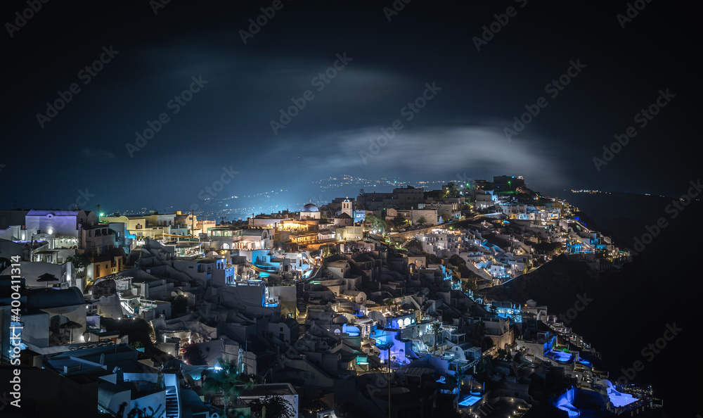 Oia town on Thira. Santorini island with colorful volcanic cliffs and deep blue sea aerial view